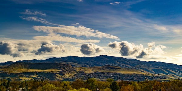 photo of Mountain Silhouette with blue sky and clouds and valley below