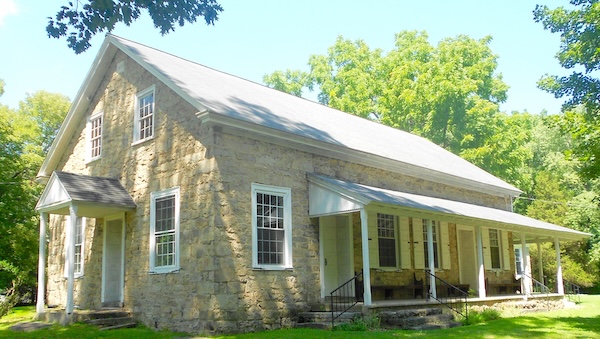 Middletown Friends Meetinghouse with blue sky and green grass