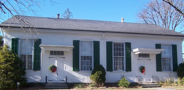 White meetinghouse with bluesy and Christmas wreaths on door