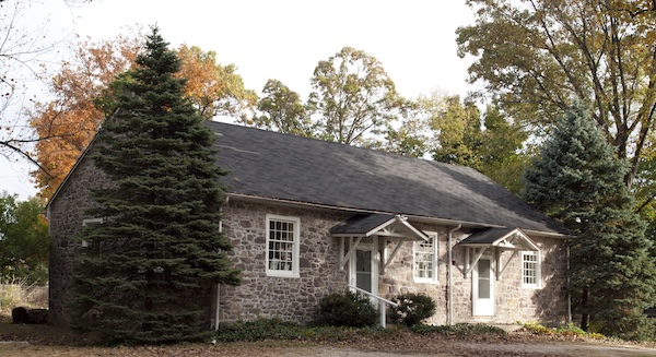 Schuylkill Friends Meeting, made of stone, with green trees outside of it!